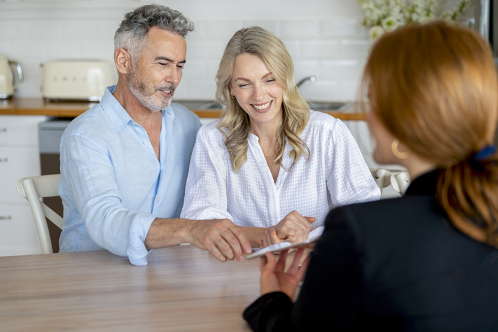 Happy mature couple meeting investments and financial advisor at home